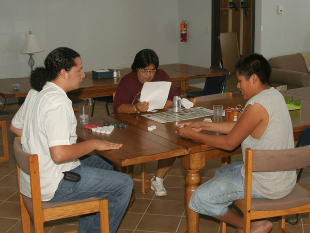 American Indian kids playing games around the table.