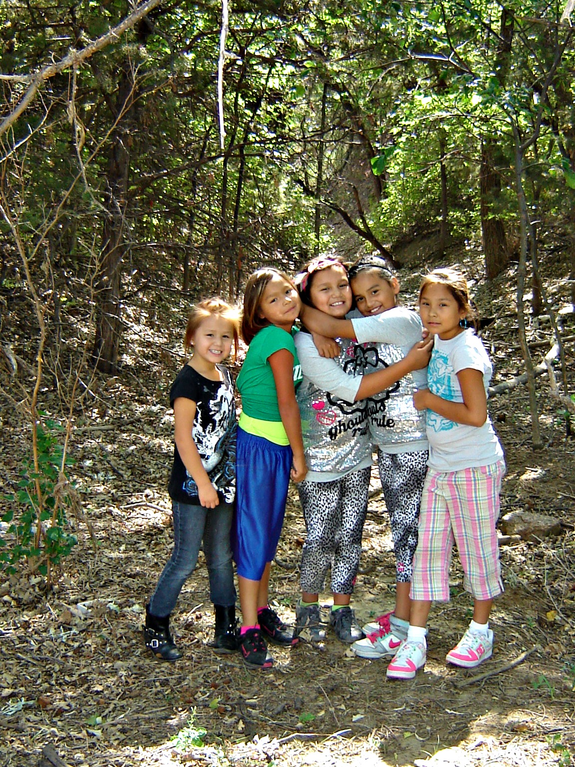 Native American girls hiking through the woods.