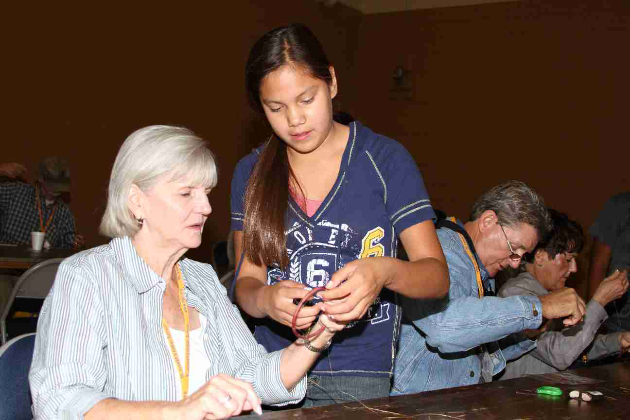 Lakota child teaches how to make dreamcatcher.