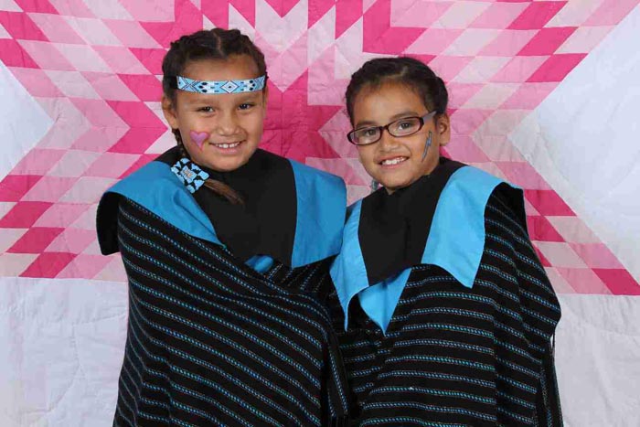 Two Native American girls showing off their regalia. 