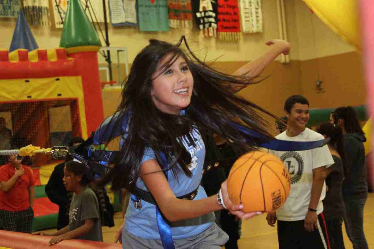 Grace tries to make a basket on the Extreme Sports Challenge during the inflatable party.