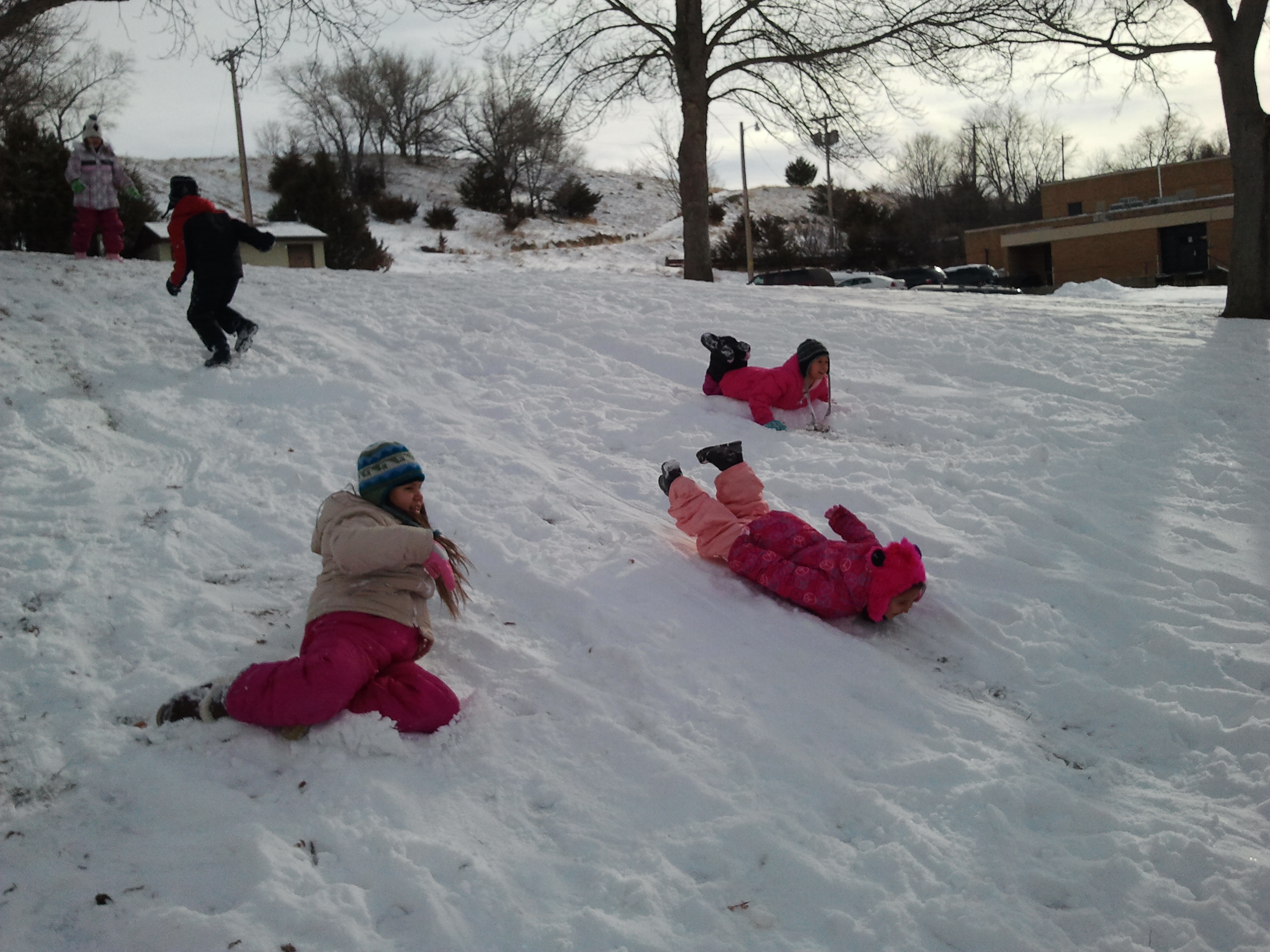 Native American youth sledding down a hill.