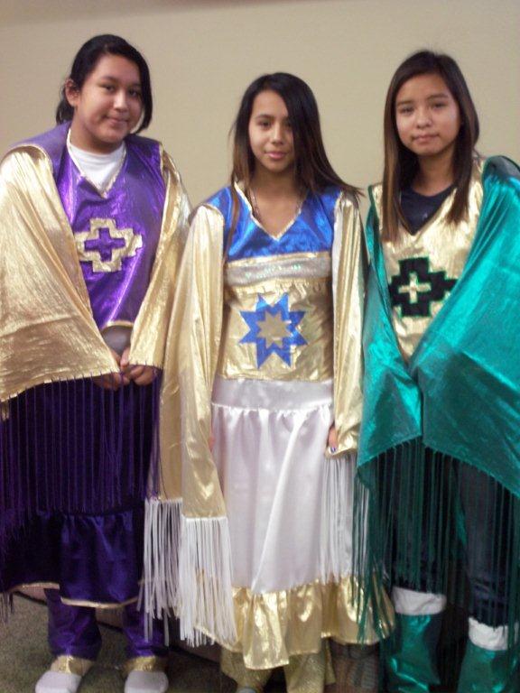 Three Native American girls showing off their beautiful regalia. 