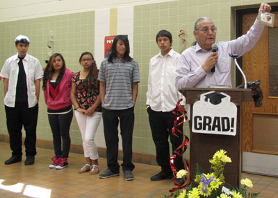 St. Joseph’s 2013 Distinguished Alumnus, Del Iron Cloud, presents a gift to the Lakota graduates. 