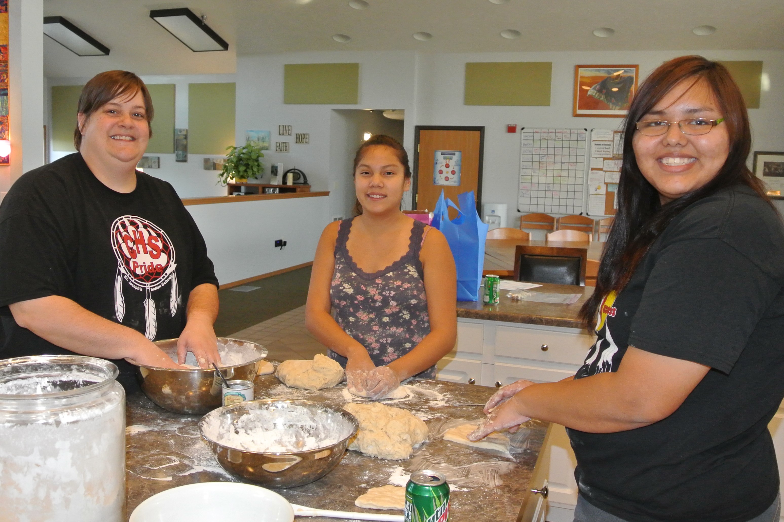 Julie and Native American students make fry bread together. 