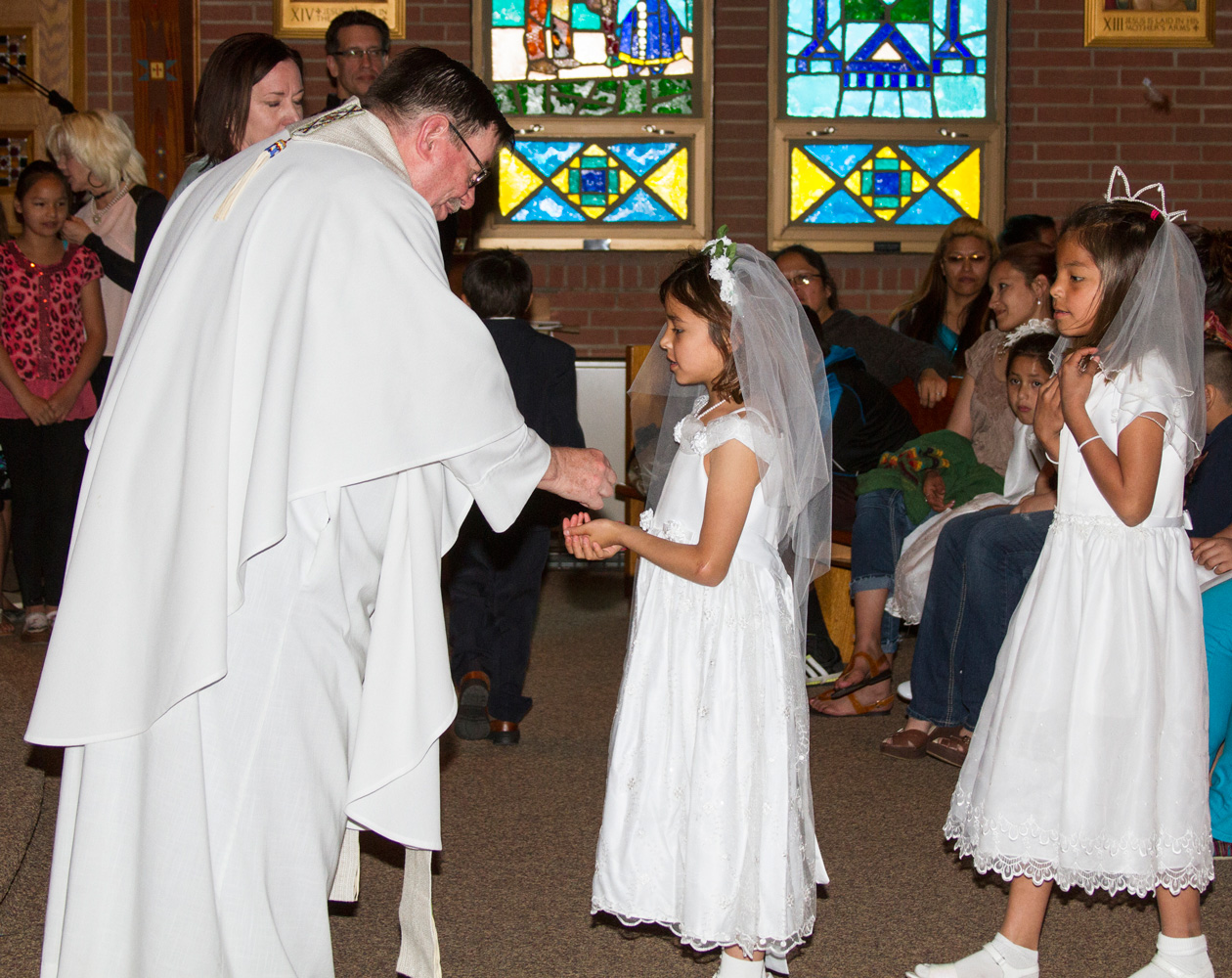 Fr. Anthony gives a Lakota child her First Holy Communion. 