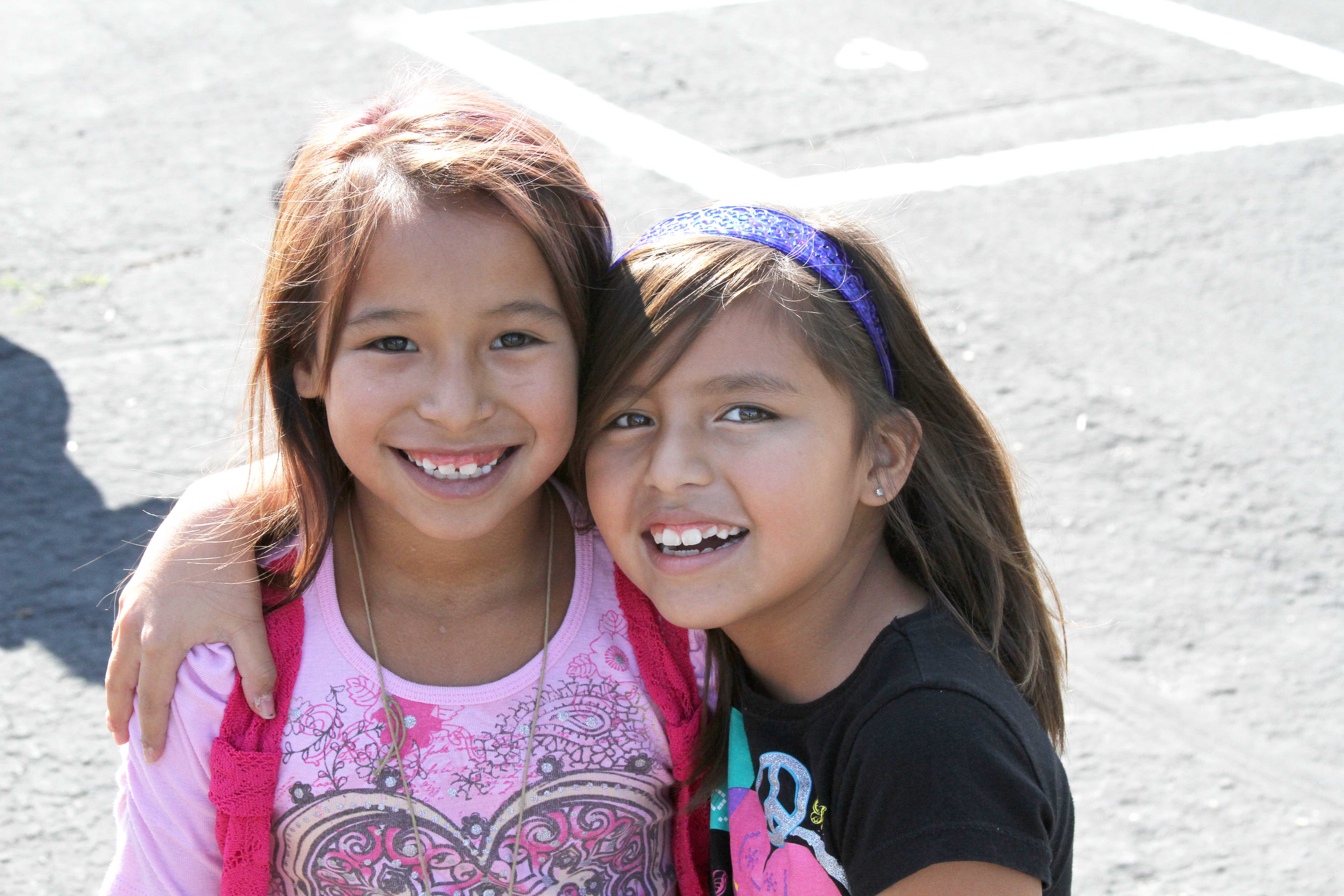 Two girls hug on the playground