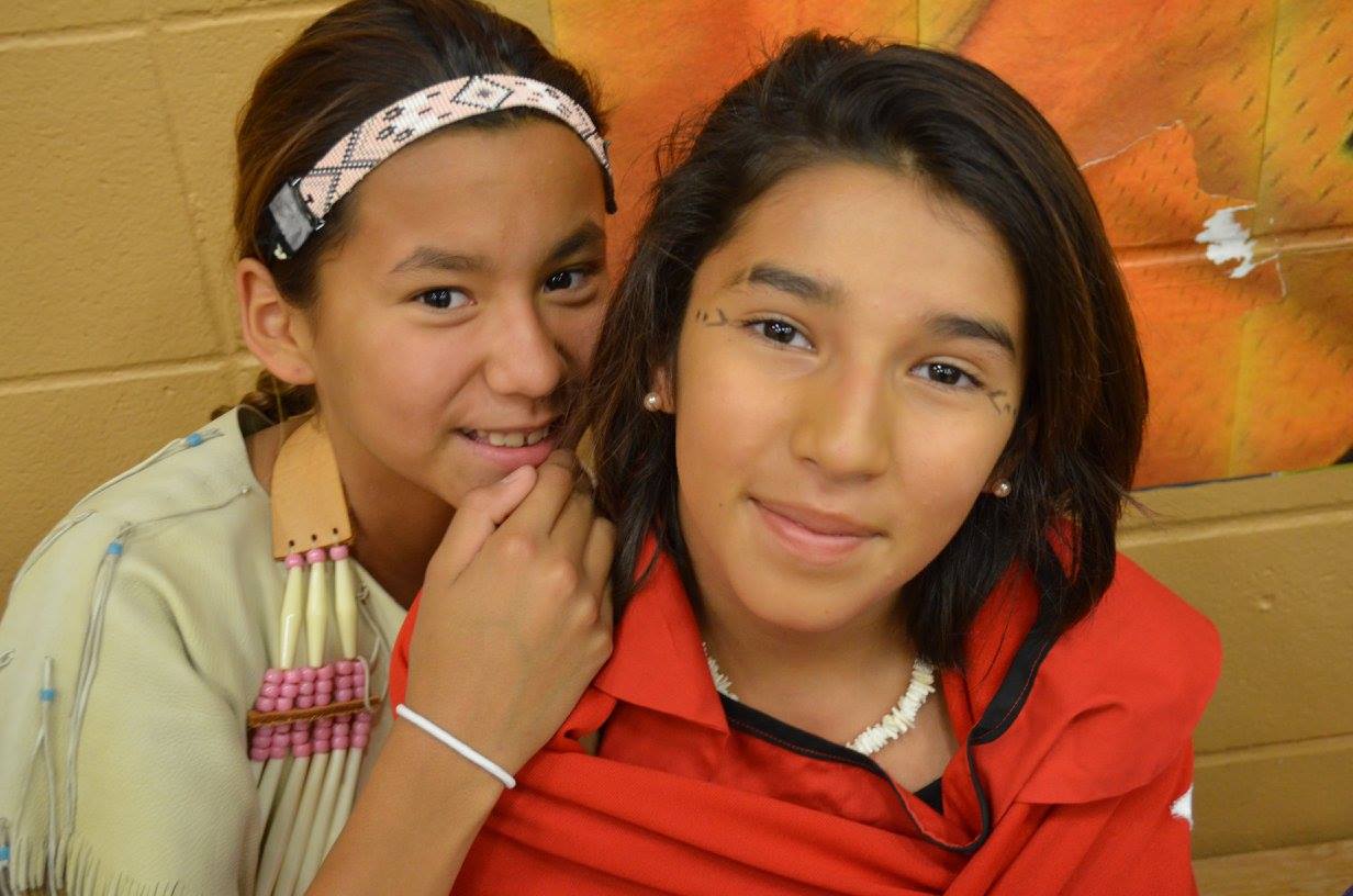 Two Lakota(Sioux) girls dressed in regalia await their turn. 