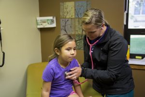 A St. Joseph’s nurse gives a check-up to a student.