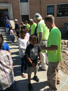 Students shake hands with construction workers.