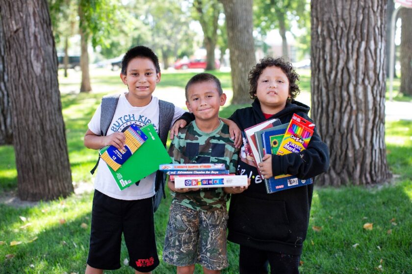 boys holding school supplies