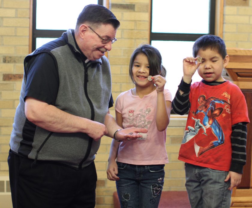 Fr. Anthony rewards the Lakota children for questions answered correctly during Mass.