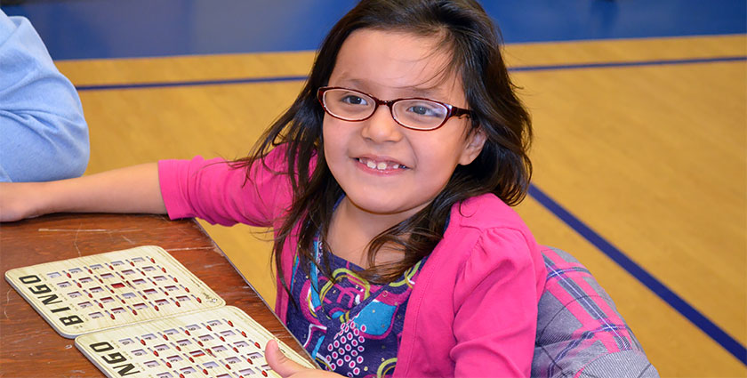 One of St. Joseph’s second-grade girls looks up from her bingo cards to smile for the camera.